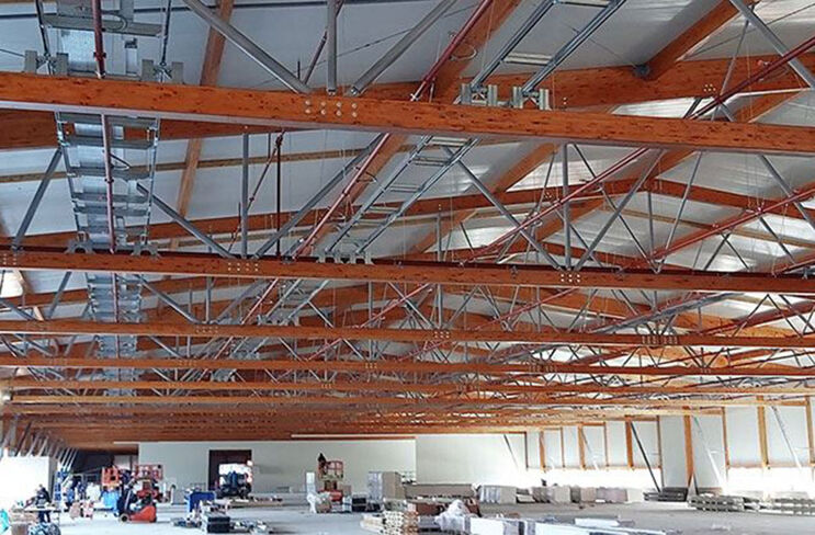 BIM geplante massive Holz-Stahl-Konstruktion überspannt Fabrikhalle
